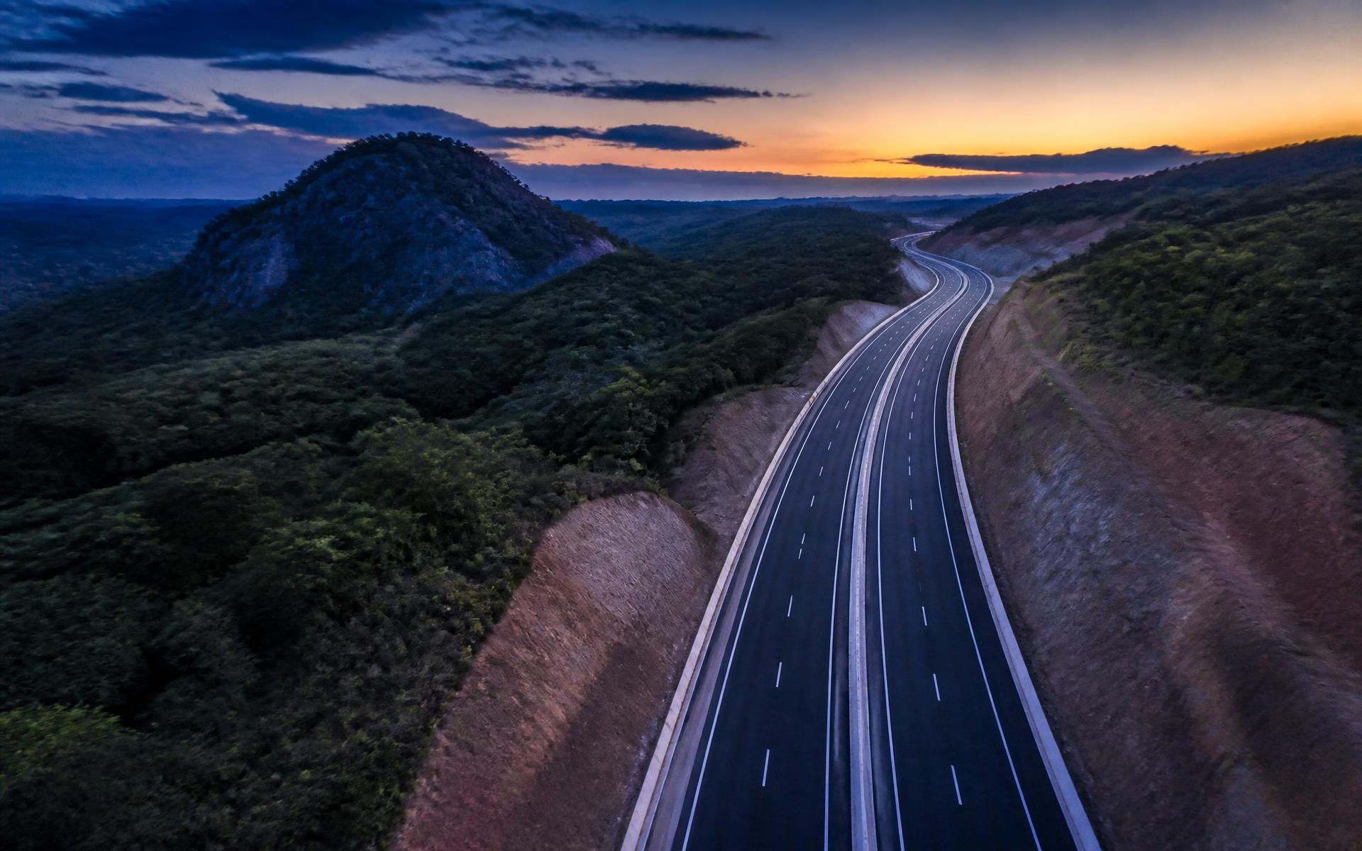 Rodovia recém-pavimentada ao anoitecer, com sinalização horizontal precisa